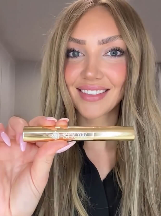 Woman smiling and holding the whitening pen